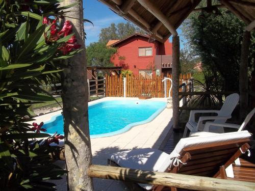 a swimming pool in a yard next to a house at Casitas Volver a Nacer in Carpintería