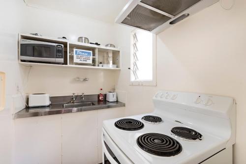 a white stove top oven in a white kitchen at Halswell Lodge in Wellington