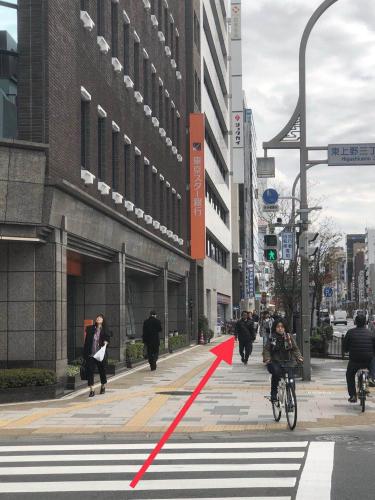 a group of people walking down a city street at GreenHotel in Tokyo