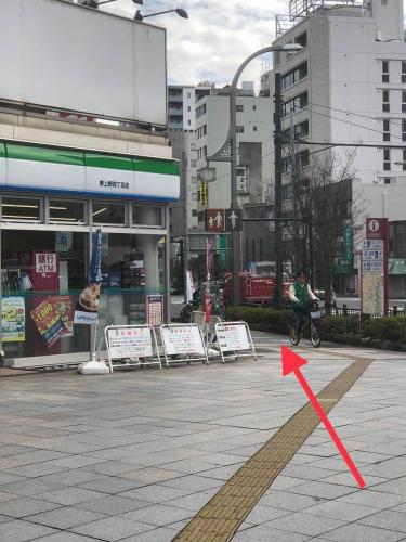 a red arrow on a street in a city at GreenHotel in Tokyo