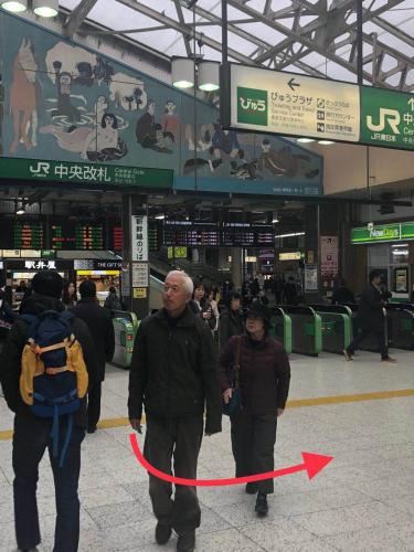 two people walking through an airport with a red ribbon at GreenHotel in Tokyo