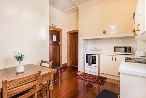 a kitchen with a wooden table and a counter top at Halswell Lodge in Wellington