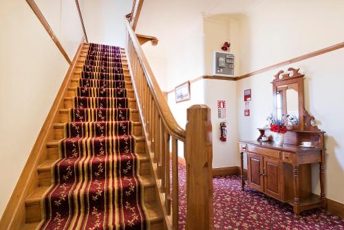 a staircase in a house with a rug on the floor at Halswell Lodge in Wellington