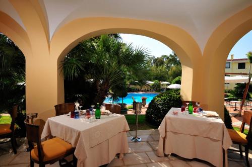 two tables in a restaurant with a view of a pool at Hotel Arbatasar in Àrbatax