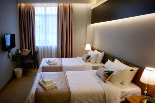 亞庇的住宿－蓋亞95酒店，酒店客房设有两张床和窗户。