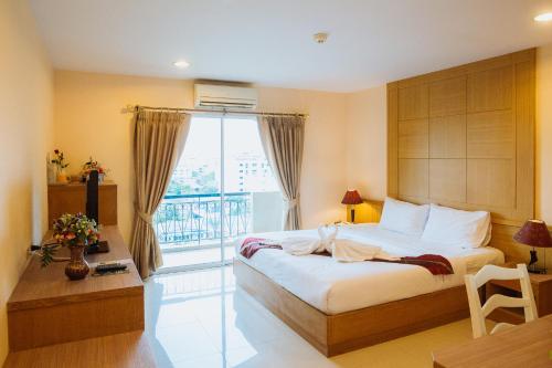 sypialnia z łóżkiem i dużym oknem w obiekcie Metro Point Bangkok w mieście Bangkok