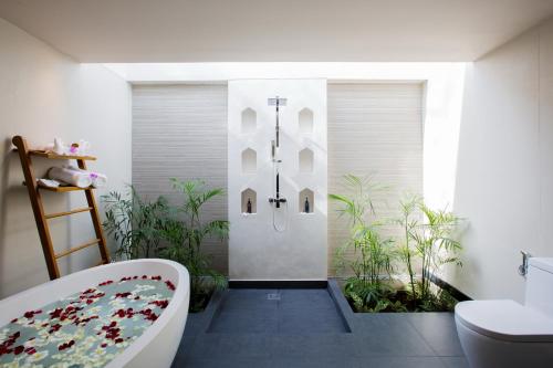 a bathroom with a bath tub and a toilet at Mandarava Resort and Spa, Karon Beach in Karon Beach