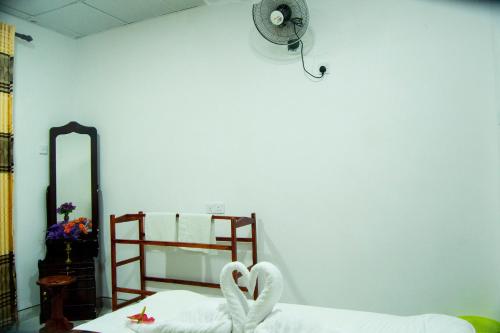two swans are sitting on a bed in a room at Senura Home Stay in Sigiriya