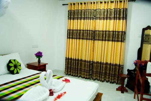 a room with a bed and a yellow curtain at Senura Home Stay in Sigiriya