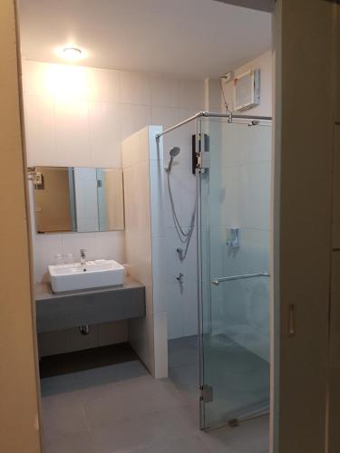 La salle de bains est pourvue d'une douche en verre et d'un lavabo. dans l'établissement DD Garden Home, à Phayao