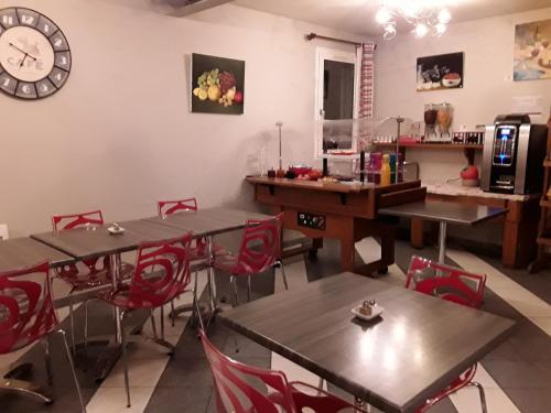 La Grange de Marie في Nitry: غرفة بطاولات وكراسي وساعة على الحائط