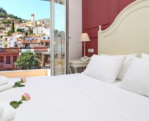 a bedroom with a white bed and a window at PEPO'S GUESTHOUSE in Nafpaktos