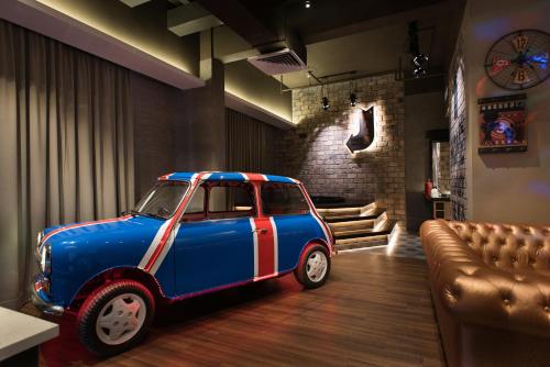 a small blue car parked in a room with a couch at Vangohh Eminent Hotel & Spa in Bukit Mertajam