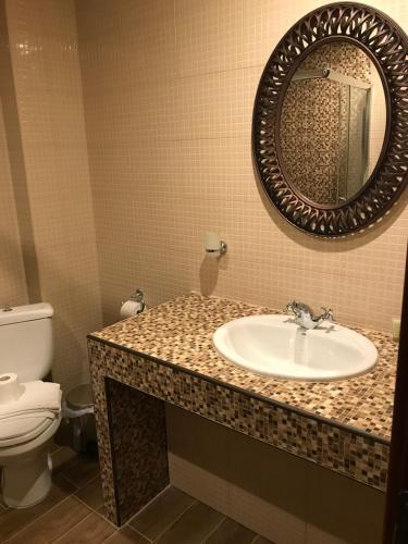 a bathroom with a sink and a toilet and a mirror at Aloni Toy Kir Thanasi Hotel & Spa in Volakas