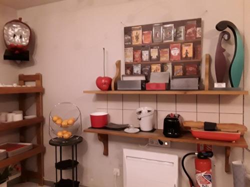 une cuisine avec des étagères en bois sur le mur dans l'établissement La Grange de Marie, à Nitry