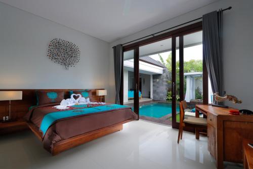 a bedroom with a bed and a swimming pool at Vansari Serenity Villa in Seminyak