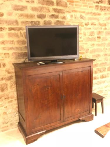 a flat screen tv on top of a wooden cabinet at Mamihouse in Gubbio