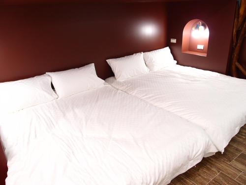 two large white beds sitting next to each other at 23 Here B&B in Hualien City
