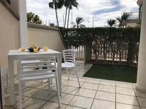 een witte tafel en stoelen op een patio bij Pasito Blanco Holiday Home - Casa Yairan in Pasito Blanco