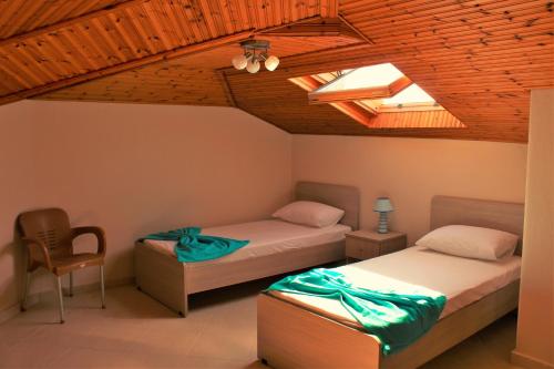 パラリア・ディオニショウにあるTheodora Villasのベッド2台と椅子が備わる客室です。