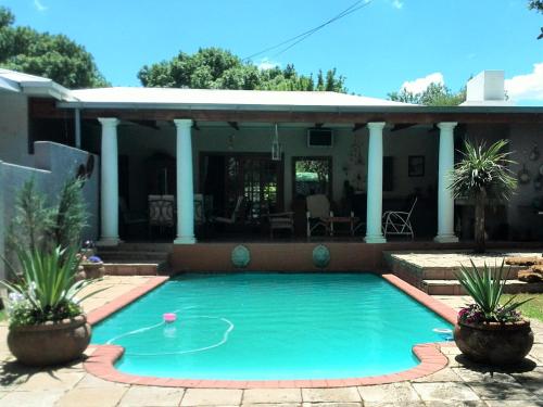 a swimming pool in front of a house at DeKat Self Catering in Burgersdorp