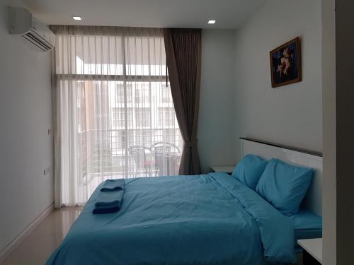 Un dormitorio con una cama azul y una ventana en Enjoy Krabi and Relax, en Klong Muang Beach