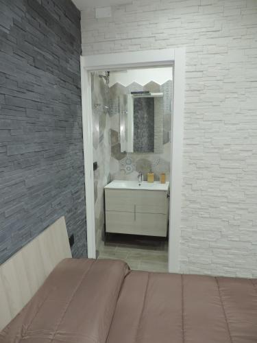 a bathroom with a bed and a sink and a mirror at La Casetta in Leporano