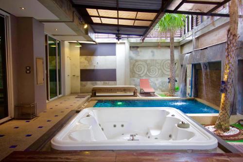 曼谷优尔纳酒店的一个带游泳池的房间的大浴缸