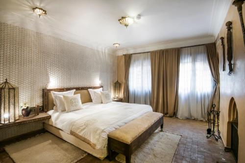Schlafzimmer mit einem großen weißen Bett und Fenstern in der Unterkunft Almaha Marrakech Restaurant & SPA in Marrakesch