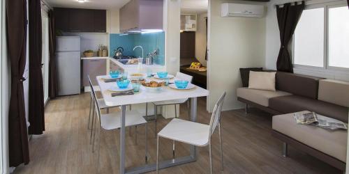 a kitchen and a living room with a table and chairs at Camping villaggio L'Ultima spiaggia in Bari Sardo