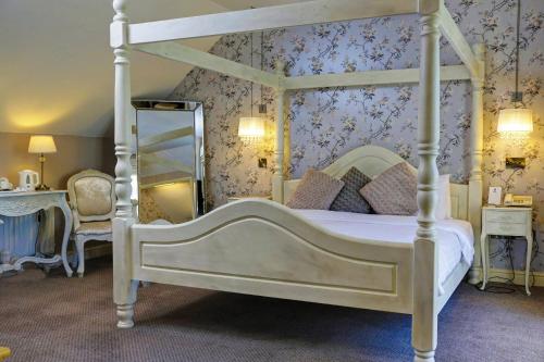 a bedroom with a white canopy bed and a mirror at Normanton Park Hotel, Sure Hotel Collection by Best Western in Oakham
