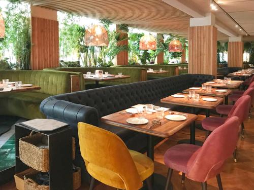 un ristorante con tavoli e sedie in legno e un divano di Hotel Inglaterra a Siviglia