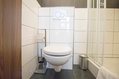 a white bathroom with a toilet and a shower at Narodni Stay in Prague