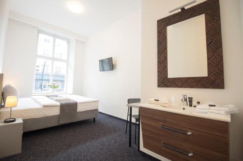 a bathroom with a bed and a sink and a mirror at Narodni Stay in Prague