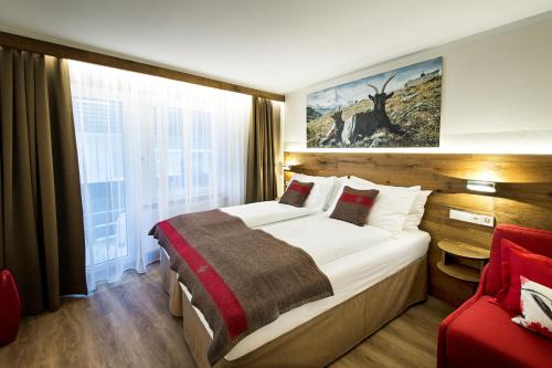 una camera d'albergo con un grande letto e una finestra di B-Inn Apartments Zermatt a Zermatt