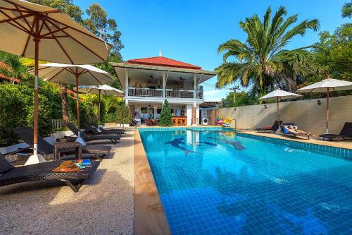 two pictures of a swimming pool with umbrellas at Lux Family Villas Krabi Ao Nang in Ao Nang Beach