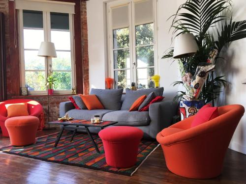 - un salon avec un canapé et des fauteuils rouges dans l'établissement Le Manoir Normand, à Trouville-sur-Mer