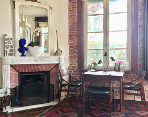 a living room with a table and a fireplace at Le Manoir Normand in Trouville-sur-Mer