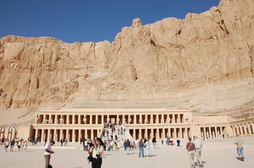 a group of people standing around a building in front of a mountain at El Mesala Hotel in Luxor