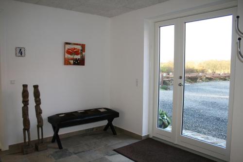 a room with a door with a bench and a window at Sov Godt i Arnborg Bed & Breakfast in Arnborg