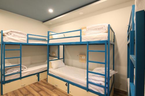 a bunk bed room with three bunk beds at Blue Beds Hostel in Jaipur