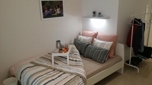 a bed with pillows and a table on it at Nafplion Smart Apartment in Nafplio