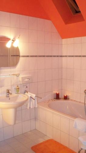 a bathroom with a sink and a bath tub at Gästehaus Musestieg in Thale