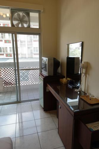 a room with a desk with a television and a window at Fa Tai An Homestay in Guangfu