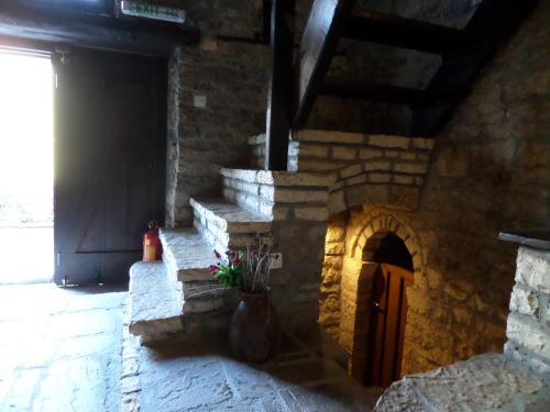 a stone fireplace in a building with a door at Arhontiko Aristis in Aristi