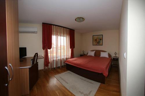 a bedroom with a red bed and a window at Pension Maria in Sibiu