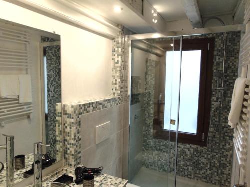 ein Bad mit einer Dusche, einem Waschbecken und einem Spiegel in der Unterkunft San Giorgio degli Schiavoni in Venedig