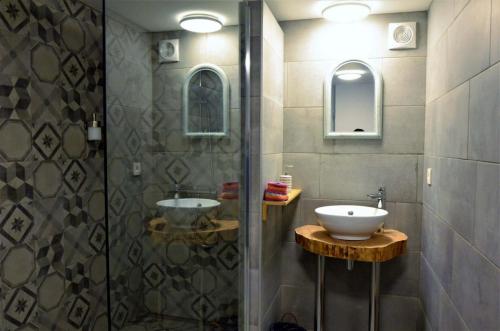 a bathroom with a glass shower and a sink at Il était une fois in Herbeumont