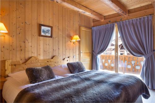 une chambre avec un grand lit et une fenêtre dans l'établissement Le Chalet d'Eléonore, aux Saisies