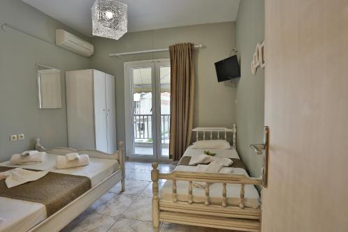 a room with two beds and a tv and a window at Villa Elena in Olympic Beach